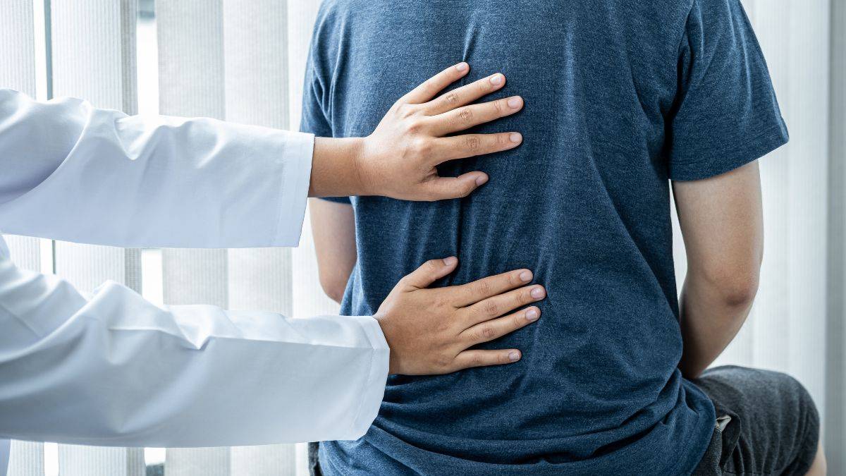 Especialista médico examinando una radiografía con problemas de columna vertebral en consulta clínica